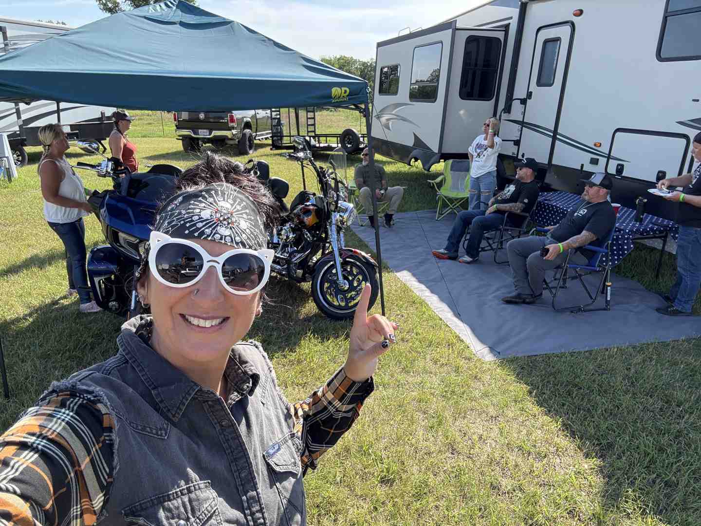 A vibrant campsite with several American-style motorcycles parked, tents set up, and people mingling, indicating a popular lodging option during the Sturgis Rally - 2026 Sturgis Rally dates