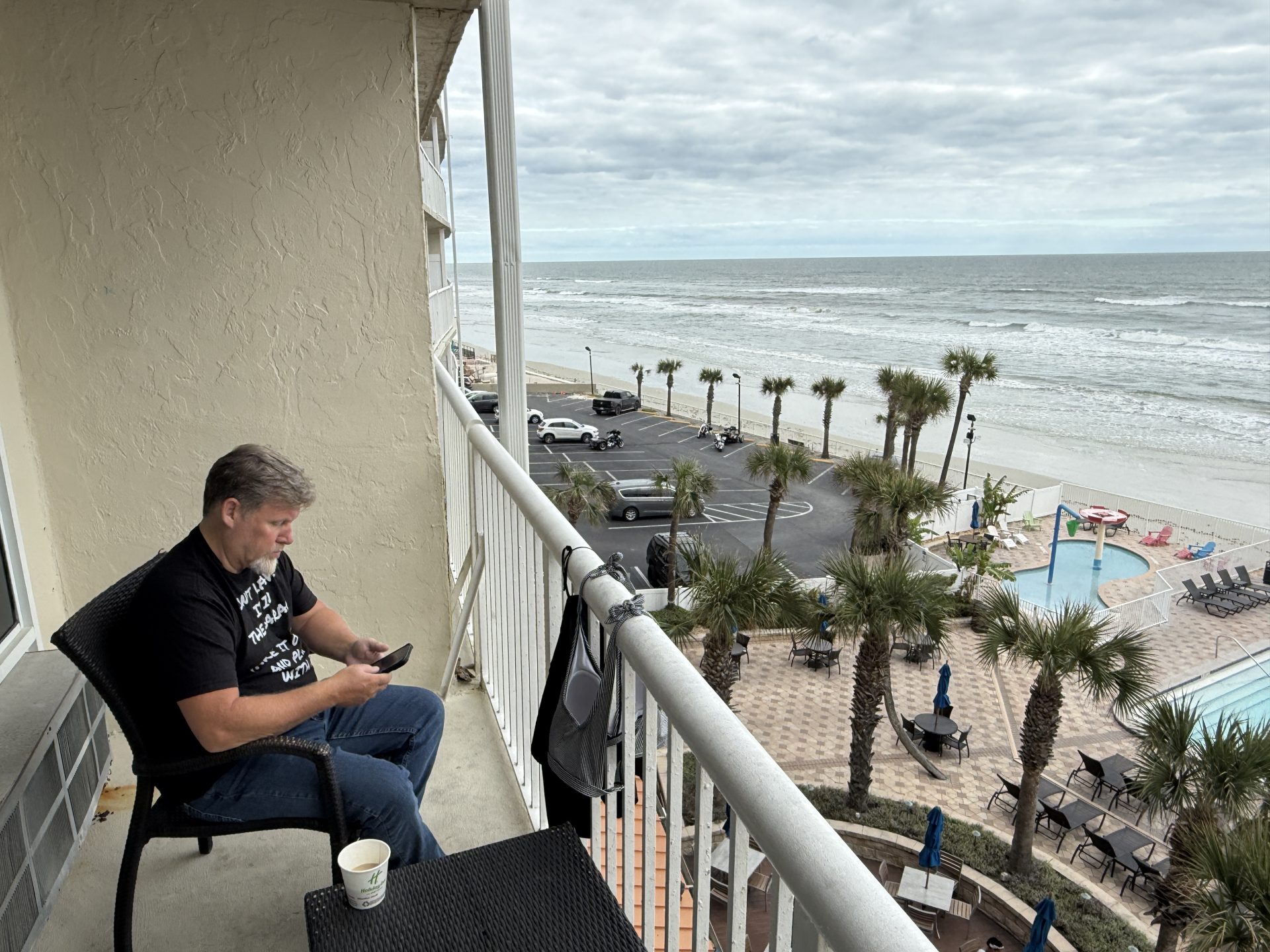 An oceanfront hotel balcony view in Daytona Beach with American style motorcycles parked below - Daytona Bike Week hotels