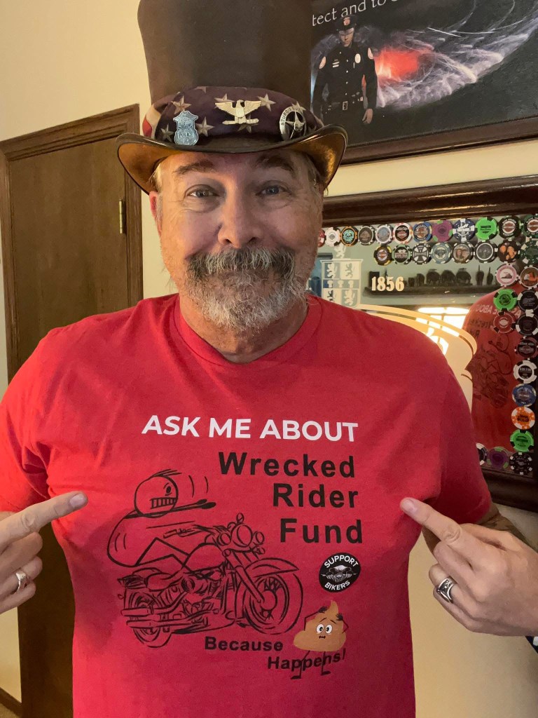 a man wearing a red shirt that says ask me about wrecked rider fund