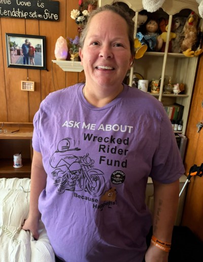 a lady wearing a purple shirt that says ask me about wrecked rider fund