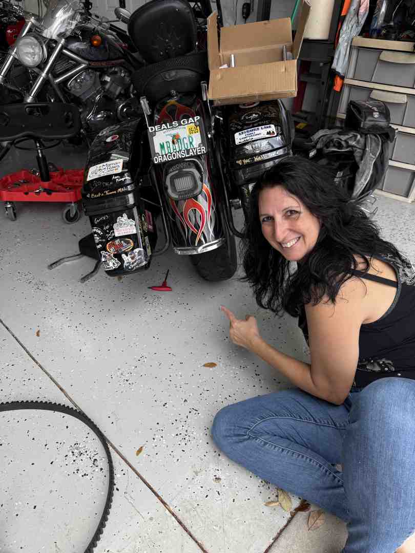 rider checking their motorcycle's tire pressure - Cruiser motorcycle fuel efficiency rider checking their motorcycle's tire pressure - Cruiser motorcycle fuel efficiency