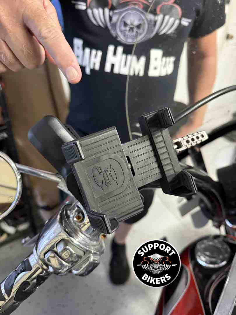 A rider using a handlebar phone mount on a sunny day in a US landscape - Gifts for motorcycle enthusiasts A rider using a handlebar phone mount on a sunny day in a US landscape - Gifts for motorcycle enthusiasts